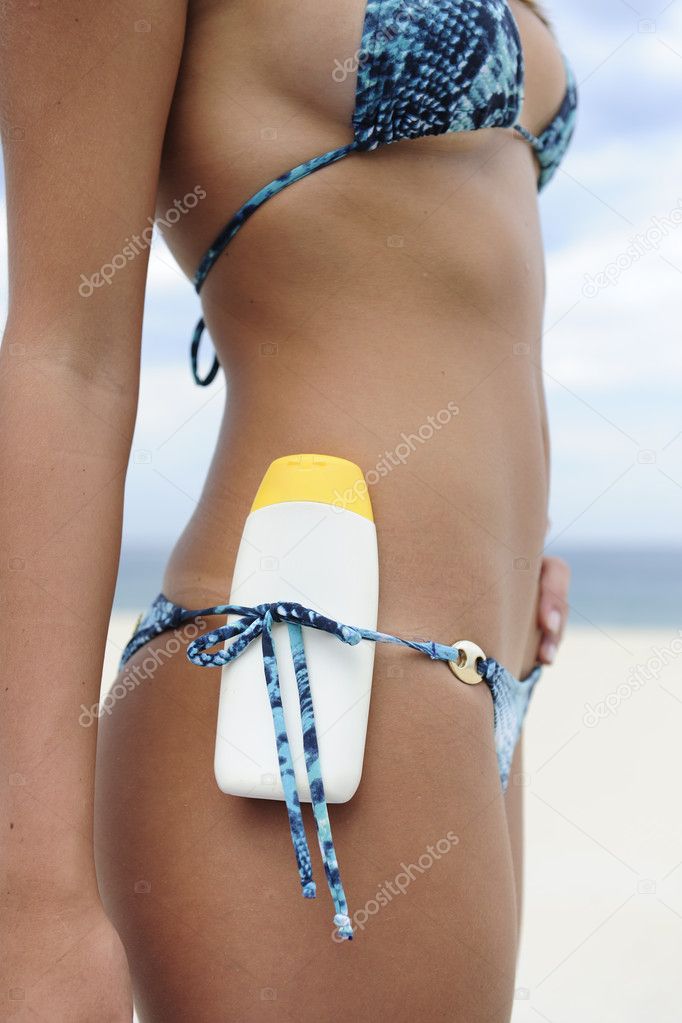 Sexy female bikini beach body with suncream