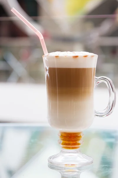Koffiekopje met artistieke crème decoratie — Stockfoto