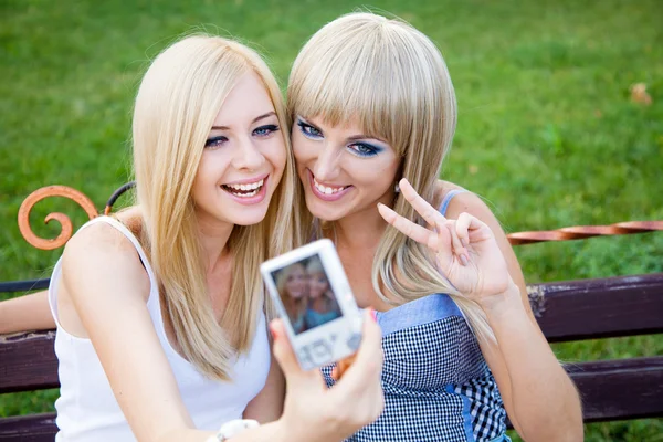 Dos hermosas amigas jóvenes con una cámara fotográfica —  Fotos de Stock