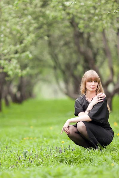 Dziewczyna siedzi na trawie — Zdjęcie stockowe