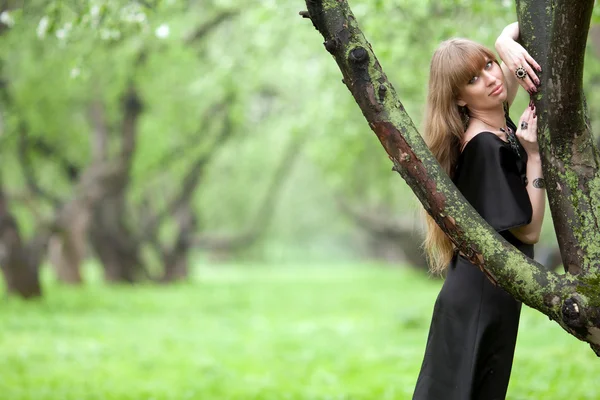Die Frau schmiegte sich an einen Baum — Stockfoto