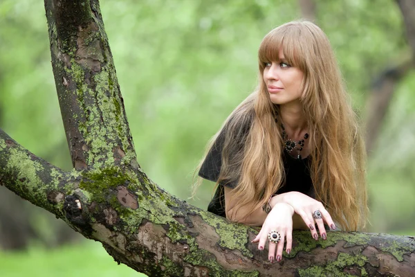La fille pencha les coudes sur un tronc d'arbre — Photo