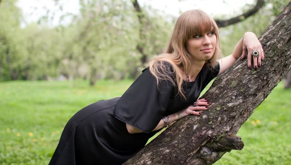 Das Mädchen auf einem Baum liegend — Stockfoto