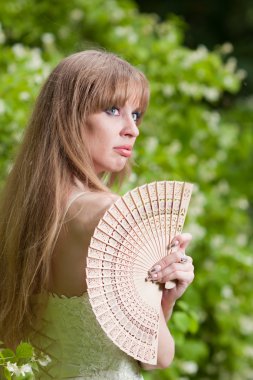 de vrouw met een ventilator in een witte jurk