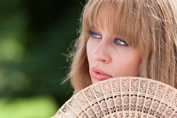 Woman's face and fan — Stock Photo, Image