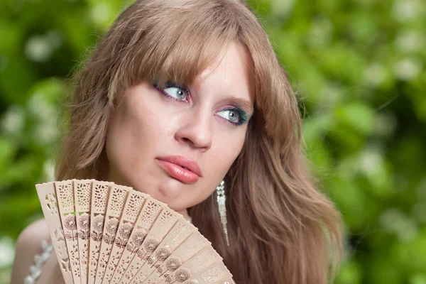 Girl's face and fan — Stock Photo, Image