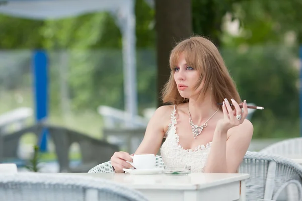 Женщина с чашкой кофе и сигаретой — стоковое фото