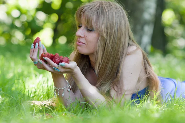 女性と一握りのイチゴ — ストック写真