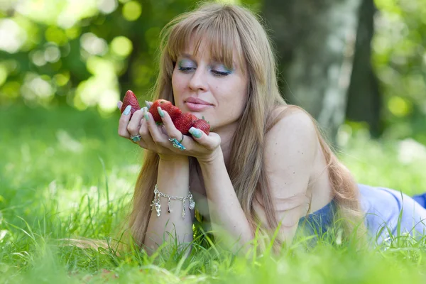 女性と一握りのイチゴ — ストック写真