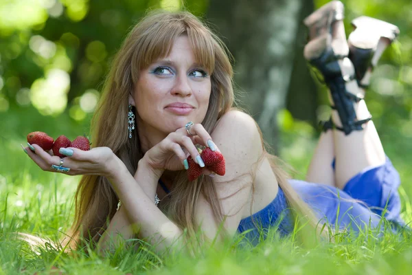 Женщина в траве и клубнике — стоковое фото