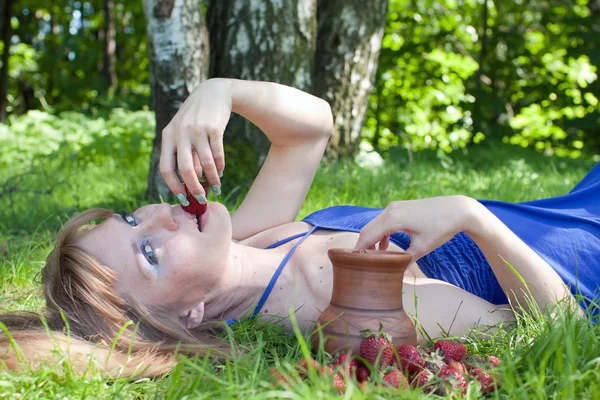 A mulher em uma grama é um morango — Fotografia de Stock