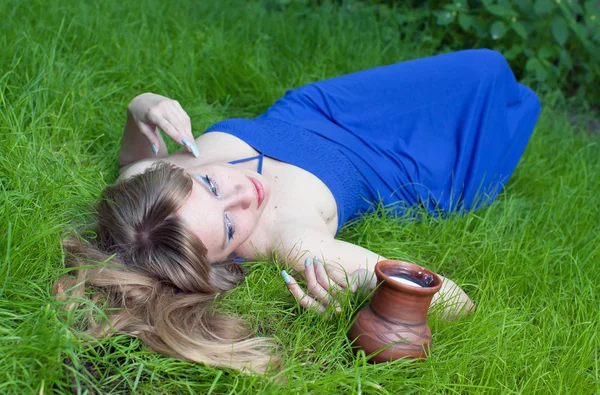 Žena v tráva a džbán mléka — Stock fotografie