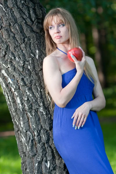 Kobieta z jabłkiem w pobliżu brzozy — Zdjęcie stockowe