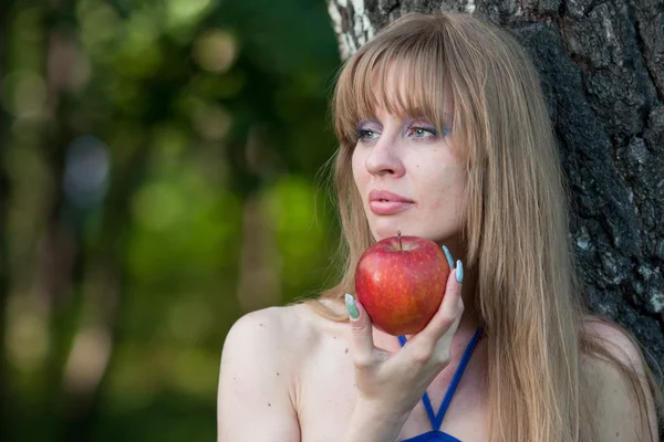 De vrouw houdt een rode appel — Stockfoto