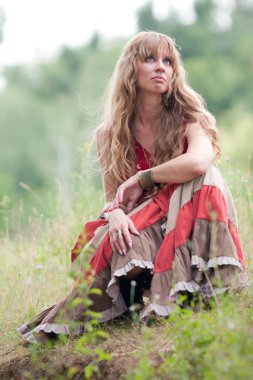 The thinking girl sits on a grass