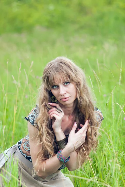 The girl of hippie costs in a grass — Stock Photo, Image