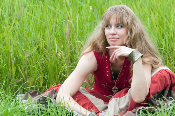 La chica pensante se sienta en una hierba — Foto de Stock