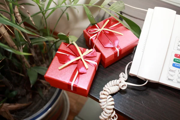 Gifts near the phone on the table — Stock Photo, Image