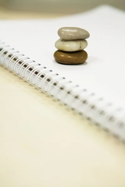Three stones on a notebook — Stock Photo, Image
