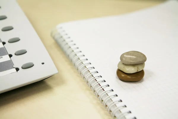 Three stones on a notebook — Stock Photo, Image