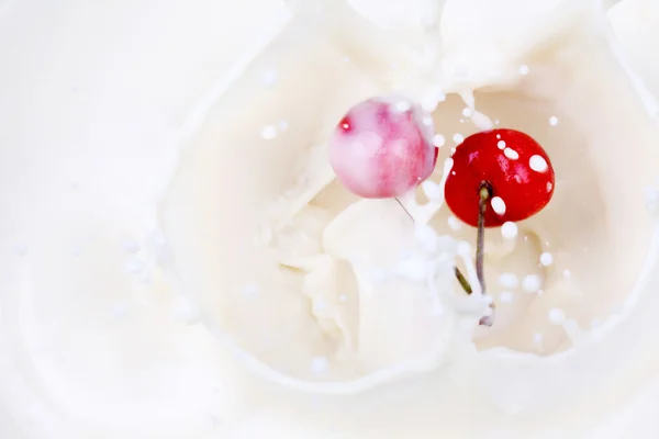 stock image A cherry falling into milk