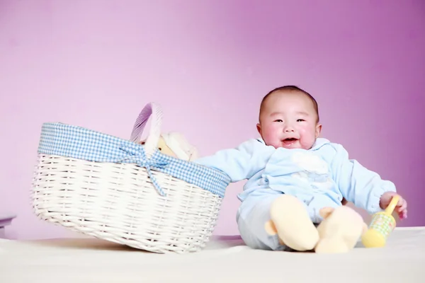 Cute baby sitting next to the basket — Stock Photo, Image
