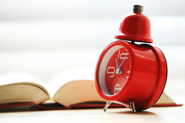Kırmızı alarm saati ile açık kitap — Stok fotoğraf