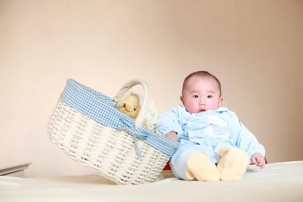 Bebê bonito sentado ao lado da cesta — Fotografia de Stock