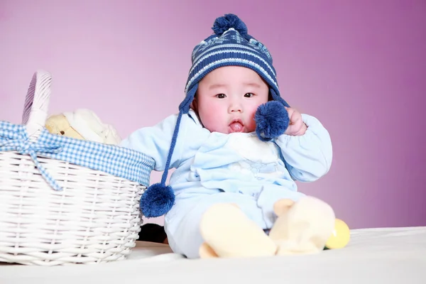 Bebê bonito sentado ao lado da cesta — Fotografia de Stock