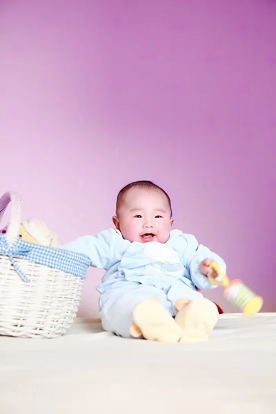 Cute baby sitting next to the basket — Stock Photo, Image
