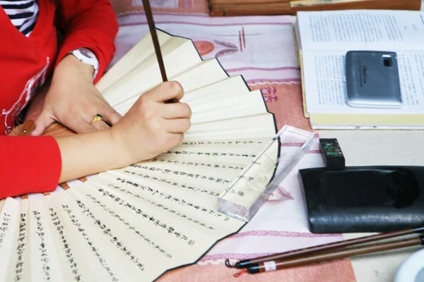 Write calligraphy on folding fan — Stock Photo, Image