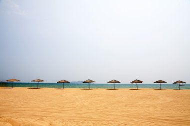 Sunshade and chairs on beach, Sanya, China clipart