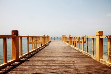 A wooden bridge over the sea clipart