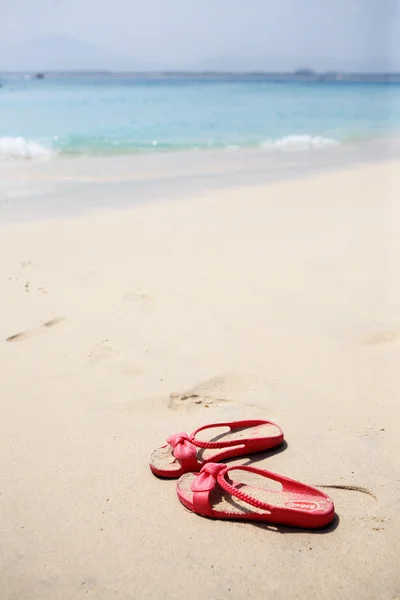 Röda tofflor i beach — Stockfoto