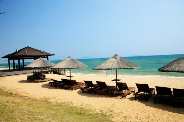 Sunshade and chairs on beach, Sanya, China clipart