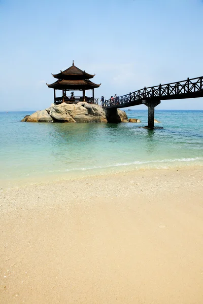 Uma ponte de madeira que leva a um pavilhão de madeira sobre o mar — Fotografia de Stock