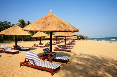 Sunshade and chairs on beach, Sanya, China clipart