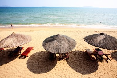 Sunshade and chairs on beach, Sanya, China clipart