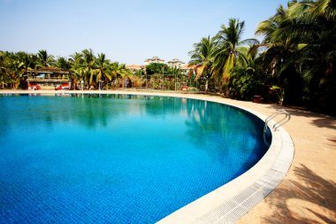 Swimming pool in china hotel with palm trees. china,Sanya clipart