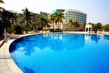 Swimming pool in china hotel with palm trees. china,Sanya clipart