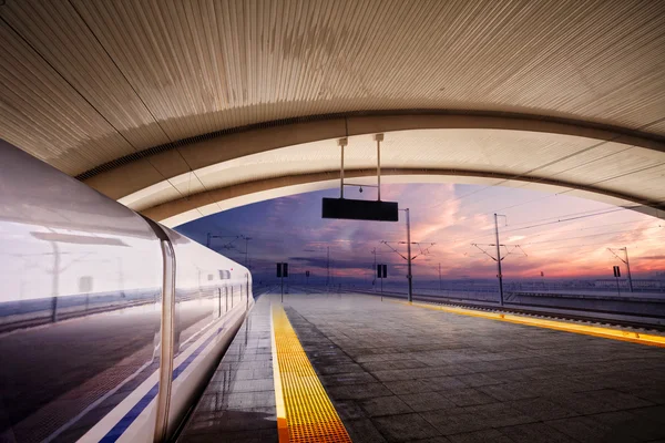 Przystanek pociągu na dworcu kolejowym z zachodem słońca — Zdjęcie stockowe