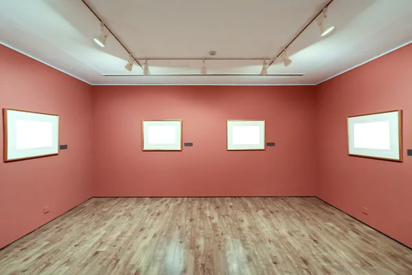 Moldura em branco em uma sala contra a parede da exposição — Fotografia de Stock