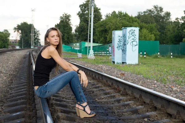 Девушка сидит на рельсах — стоковое фото