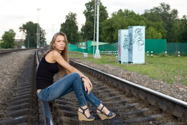 女孩坐在铁轨上 — 图库照片