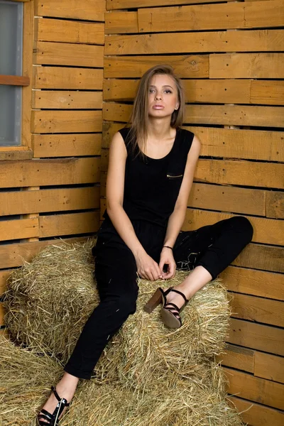 Meisje, zittend op hooi — Stockfoto