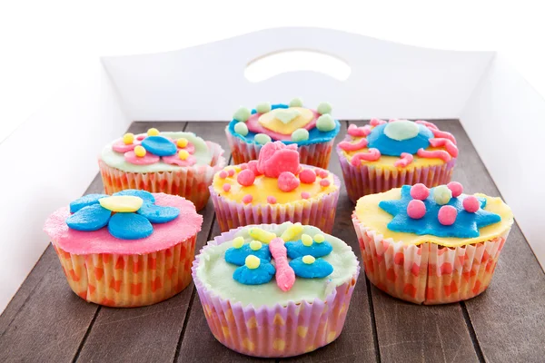 Bricka med färgglada dekorerade cupcakes — Stockfoto