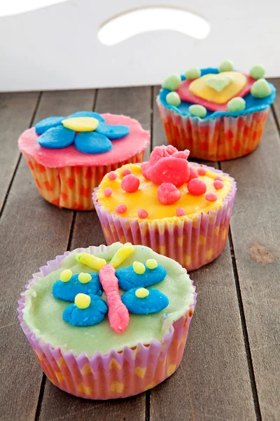 Bricka med färgglada dekorerade cupcakes — Stockfoto