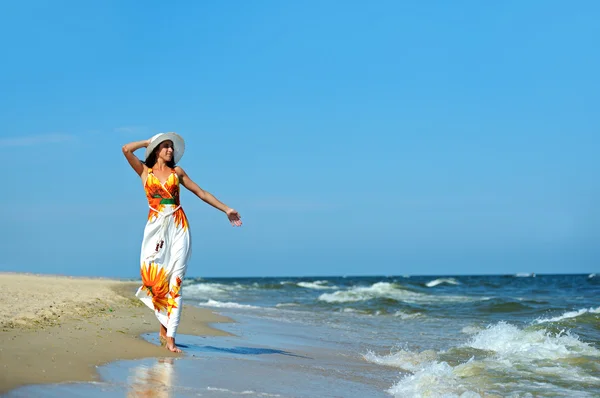 Žena kráčející po pláži — Stock fotografie