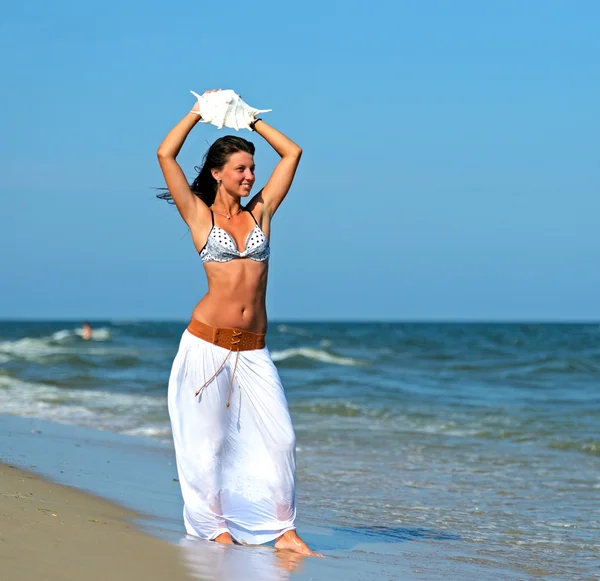 Eine Frau geht am Strand spazieren — Stockfoto