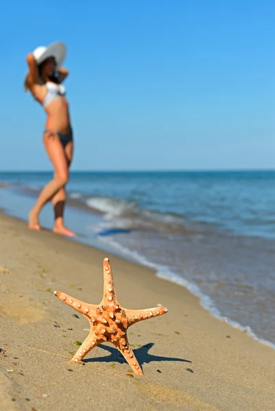 En kvinne som går på stranden – stockfoto